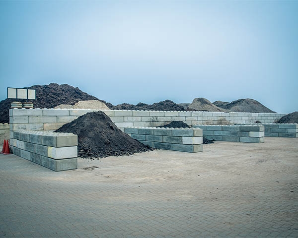 Opslagvakken van betonstapelblokken op een depot van Van Werven, gevuld met grond, zand en compost