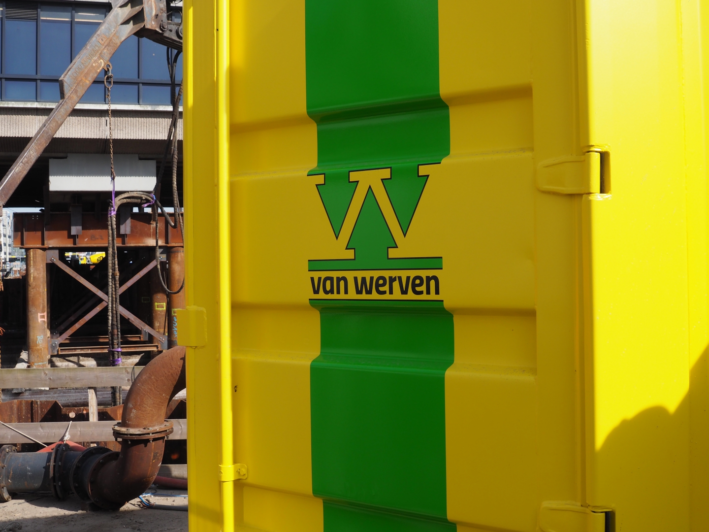 Geel-groene materieelcontainer van Van Werven op een bouwterrein