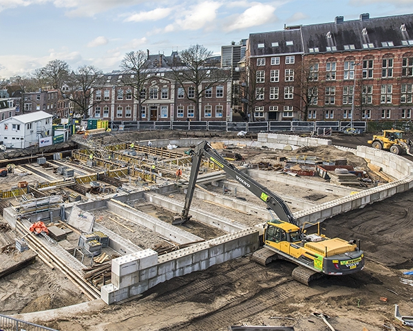 Langarmkraan werkt in de betonnen bouwkuip van parkeergarage Garenmarkt, omringd door historische panden