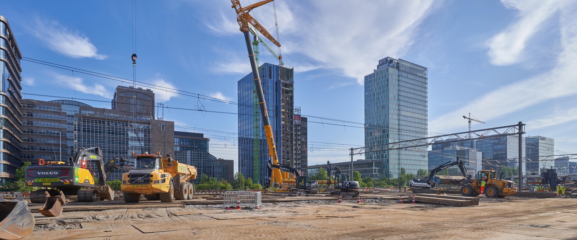 Machines van Van Werven aan het werk op een bouwterrein op de Amsterdamse Zuidas