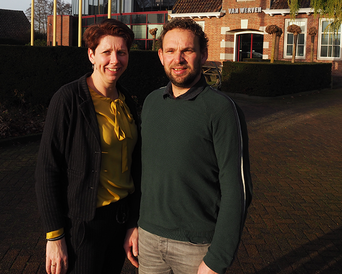 Een vrouw en een man poseren voor het kantoorpand van Van Werven